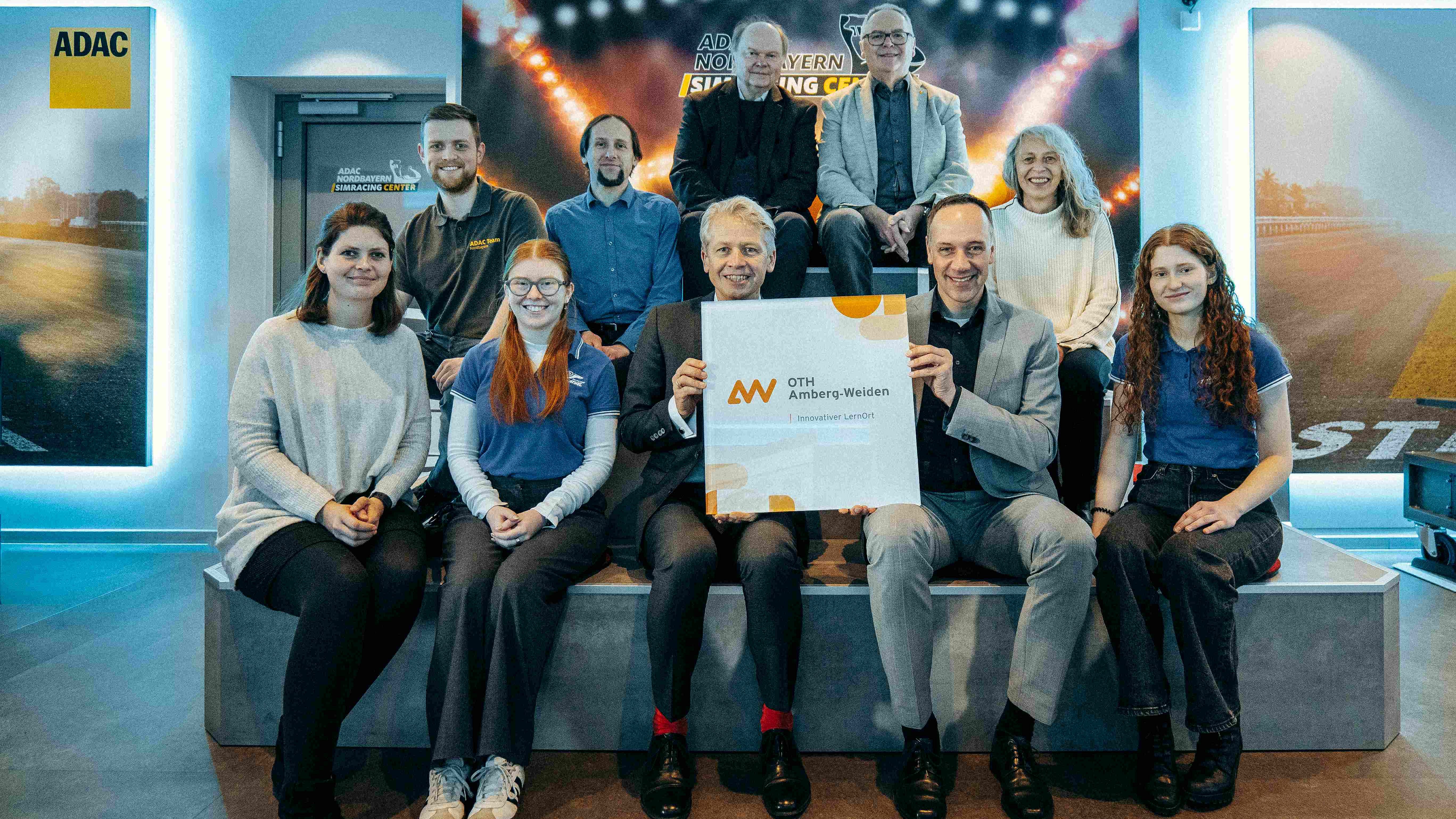 Bei der Unterzeichnung dabei (v.l.): Hanna Gallitzendörfer (Projektleitung Innovative LernOrte), Fabian Bezdiczka (Leitung SimRacing-Center), Leonie Schweickert (Leitung PR & Organisation Running Snail Racing Team), Prof. Dr. Tobias Skubacz, Prof. Dr. Clemens Bulitta (Präsident OTH Amberg-Weiden), Prof. Dr. Wolfgang Weber (Vizepräsident OTH Amberg-Weiden), Michael Bayer (Vorstandsmitglied Jugend und Sport ADAC Nordbayern), Dr. Matthias Köck (Vorsitzender ADAC Nordbayern), Petra Brunner (Leitung Sport und Ortsclubs), Marion Kraus (Teamleitung Running Snail Racing Team)